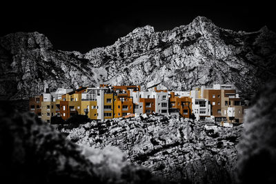 Snow covered buildings against mountain