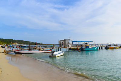 Boats moored on beach against sky