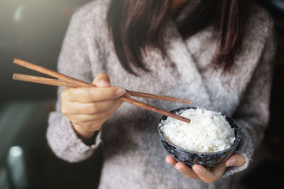 Midsection of woman holding ice cream in bowl