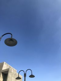 Low angle view of street light against blue sky