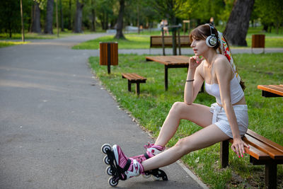 Side view of woman sitting on road