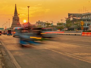 Blurred motion of vehicles on road against sky during sunset