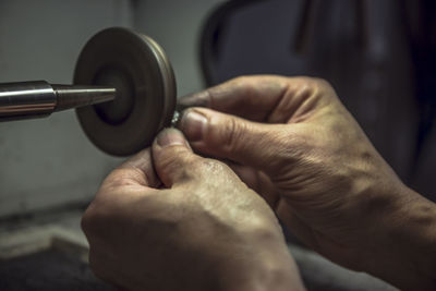 Close-up of hands polishing metal in factory