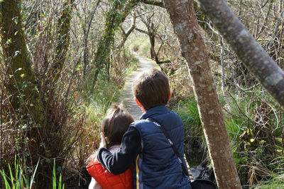 Rear view of father and daughter in forest