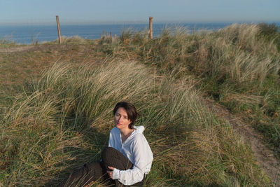 Full length of woman sitting on land