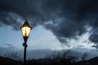 Low angle view of street light against cloudy sky