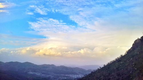 Scenic view of mountains against cloudy sky