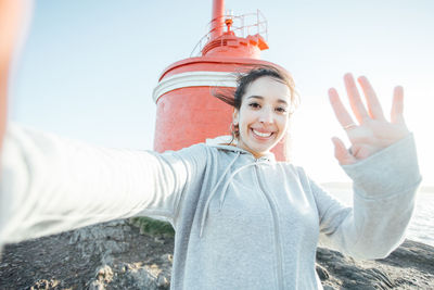 Cropped hand of woman with arms raised standing against wall