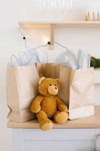 Soft toy bear near craft paper bags