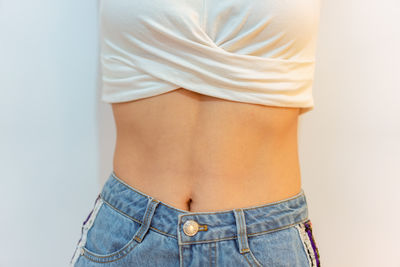 Midsection of woman standing against white background