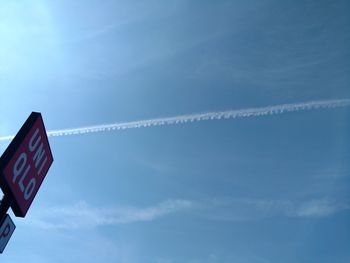 Low angle view of vapor trail against blue sky