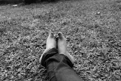 Low section of woman in toe rings relaxing on grassy field