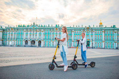 Women against cloudy sky in city