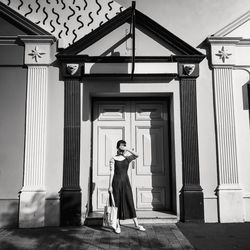 Full length of woman standing against building