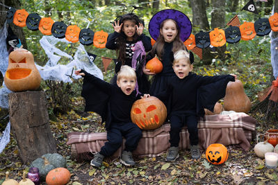 Happy kids in halloween costumes having fun in halloween decorations outdoor