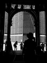 Rear view of silhouette people walking in building