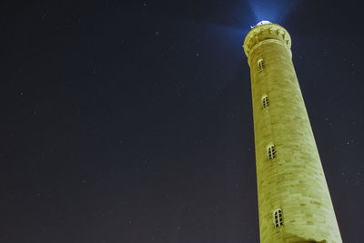 Low angle view of illuminated tower against sky at night