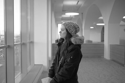 Side view of woman standing in front of building