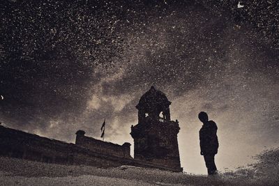 Silhouette people standing against sky at night