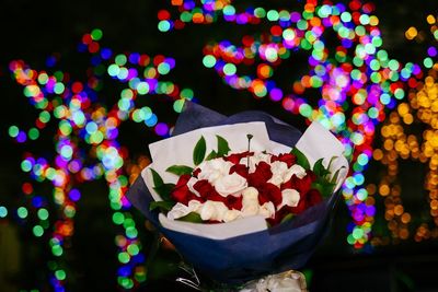 Bouquet of roses against multi colored defocused lights