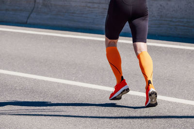 Low section of woman walking on road