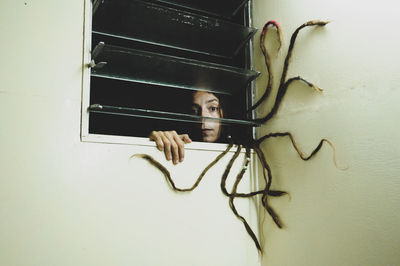 Portrait of woman with dreadlocks at home