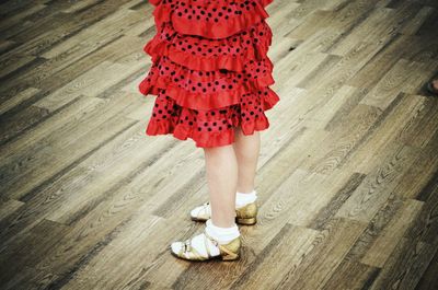 Low section of woman standing on hardwood floor