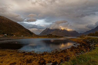 Scenic view of lake by mountains against sky