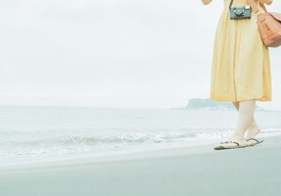 Low section of woman standing on beach