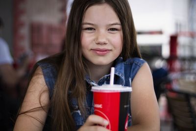 Portrait of a smiling young woman holding drink