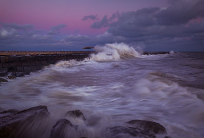 Waves splashing on sea against sky