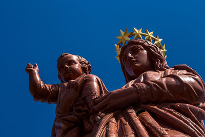 Low angle view of statue against clear blue sky