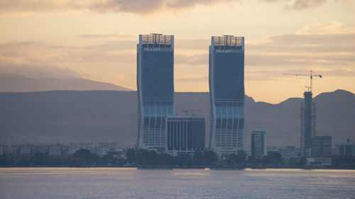 Modern buildings against sky during sunset in city