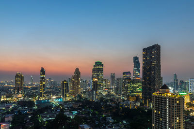 Illuminated buildings in city against sky