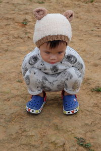 High angle view of baby boy crouching on field