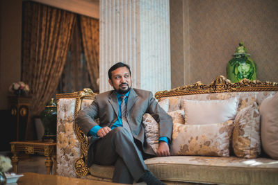 Portrait of young man sitting on sofa at home