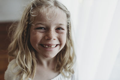 Portrait of young freckled smiling girl missing tooth