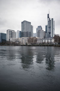 River and buildings against sky in city