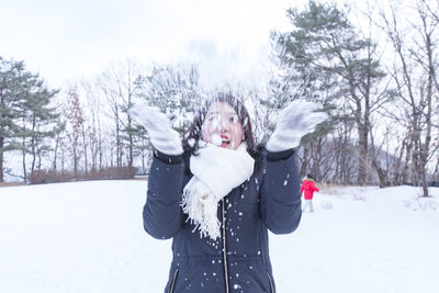 Portrait of young woman standing on snow covered landscape