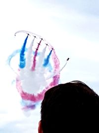 Rear view of woman flying kite against sky