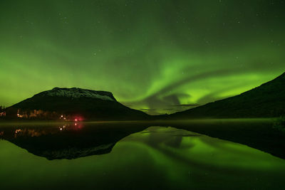 Scenic view of lake against northern lights at night