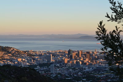 High angle view of city at waterfront during sunset