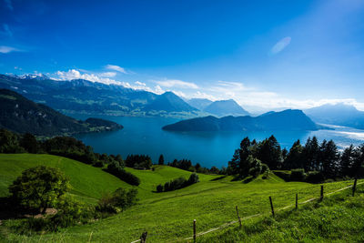 Scenic view of field and mountains against blue sky