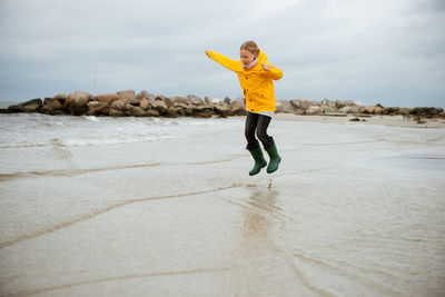 Full length of girl jumping at beach