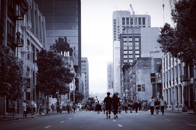 People walking on road along buildings