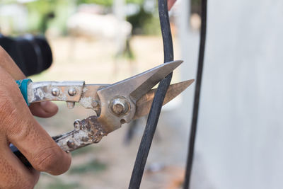 Close-up of hand cutting cable