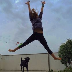 Full length of woman jumping against sky