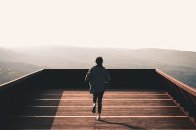 Woman running on wooden balcony