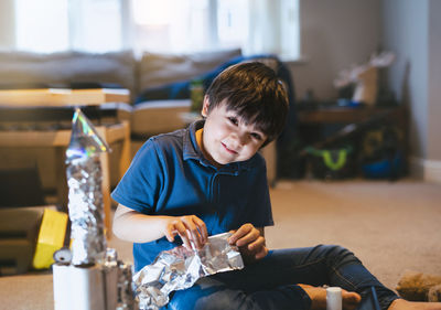 Full length of boy sitting on table