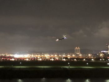 Aerial view of illuminated city against sky at night